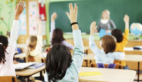 Alumnos levantando la mano en el colegio